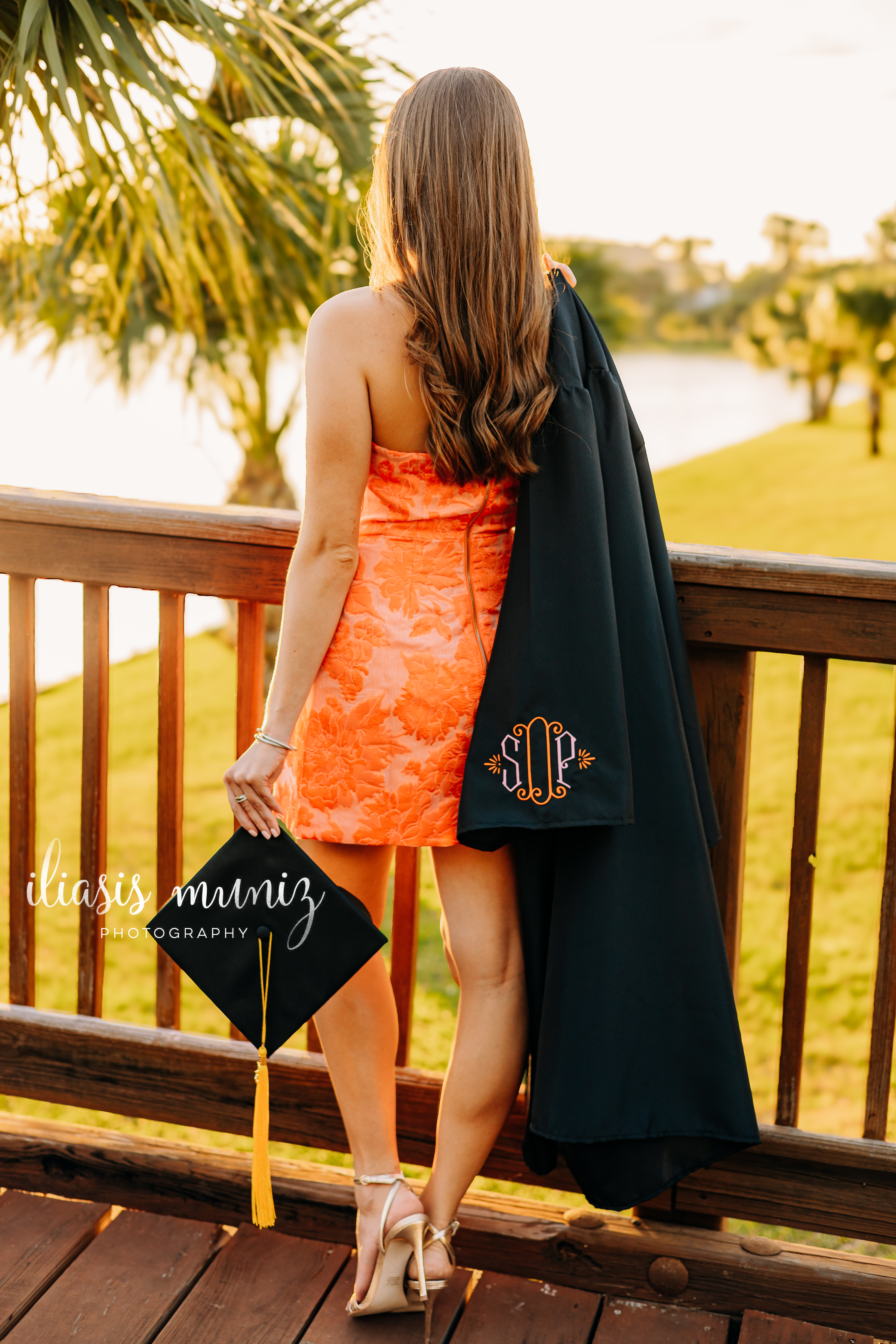 "Graduate standing on the wooden bridge at UTRGV Fort Brown Resaca"