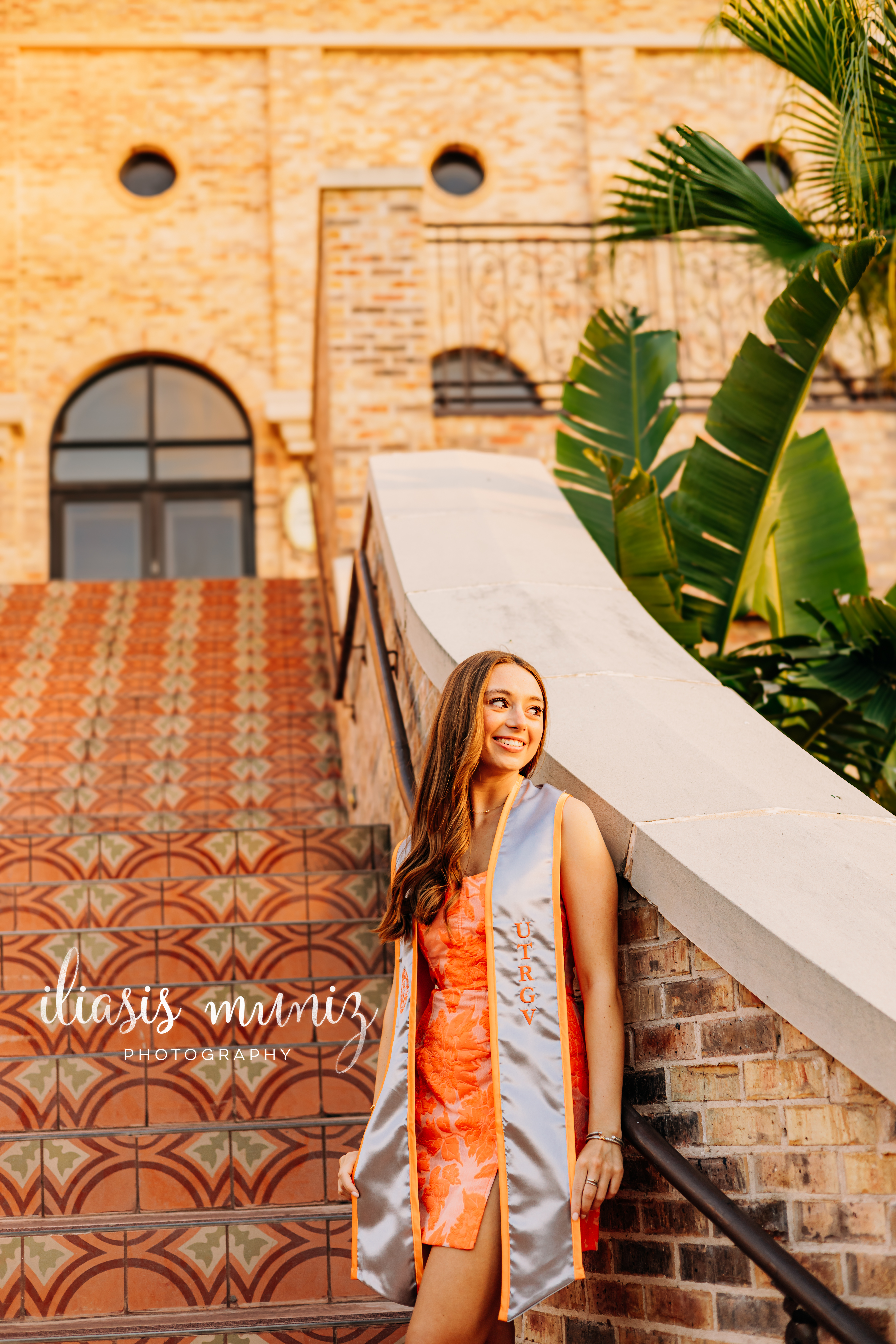 "Graduate sitting on colorful tiled staircase at UTRGV"