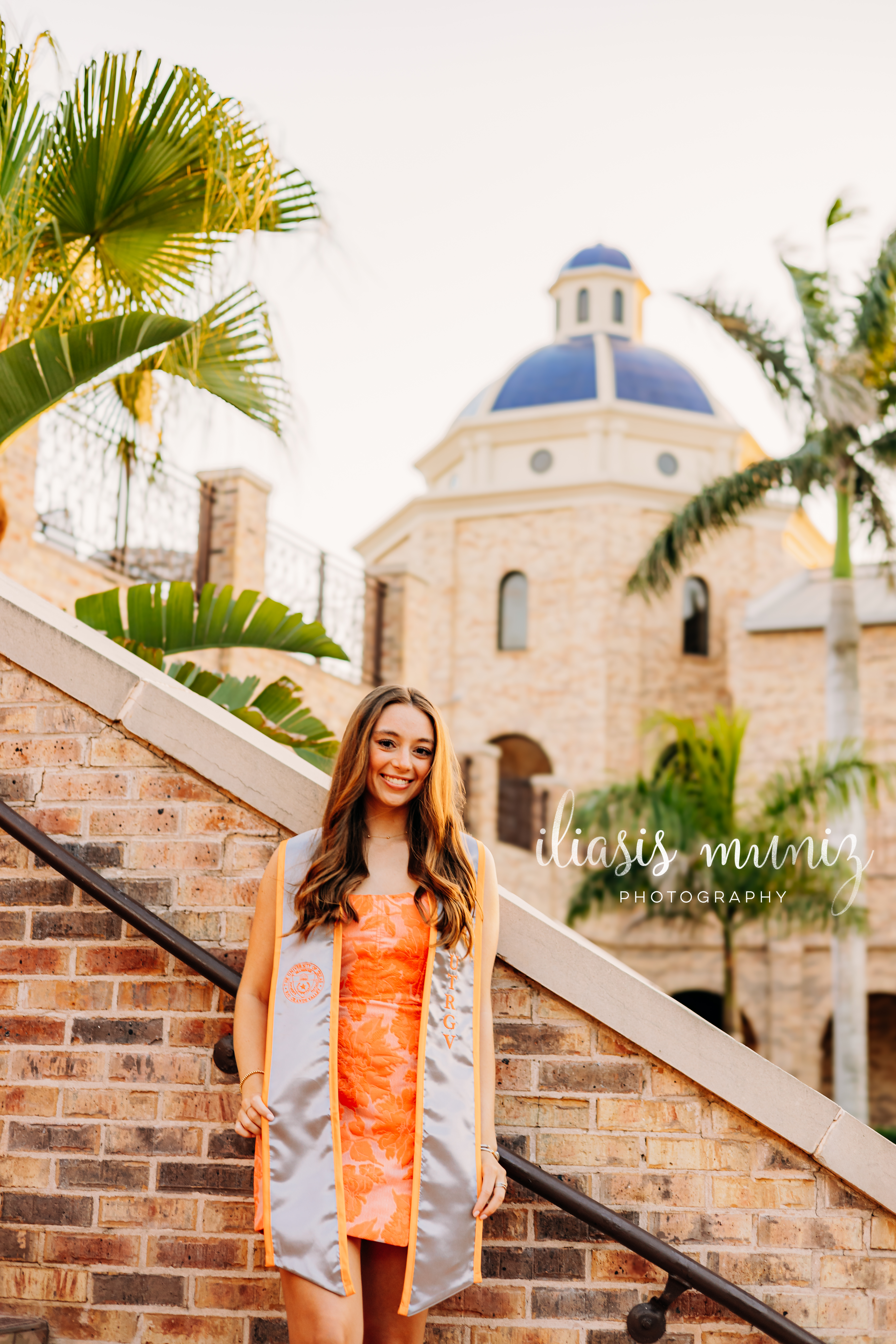 "Graduate sitting on colorful tiled staircase at UTRGV"