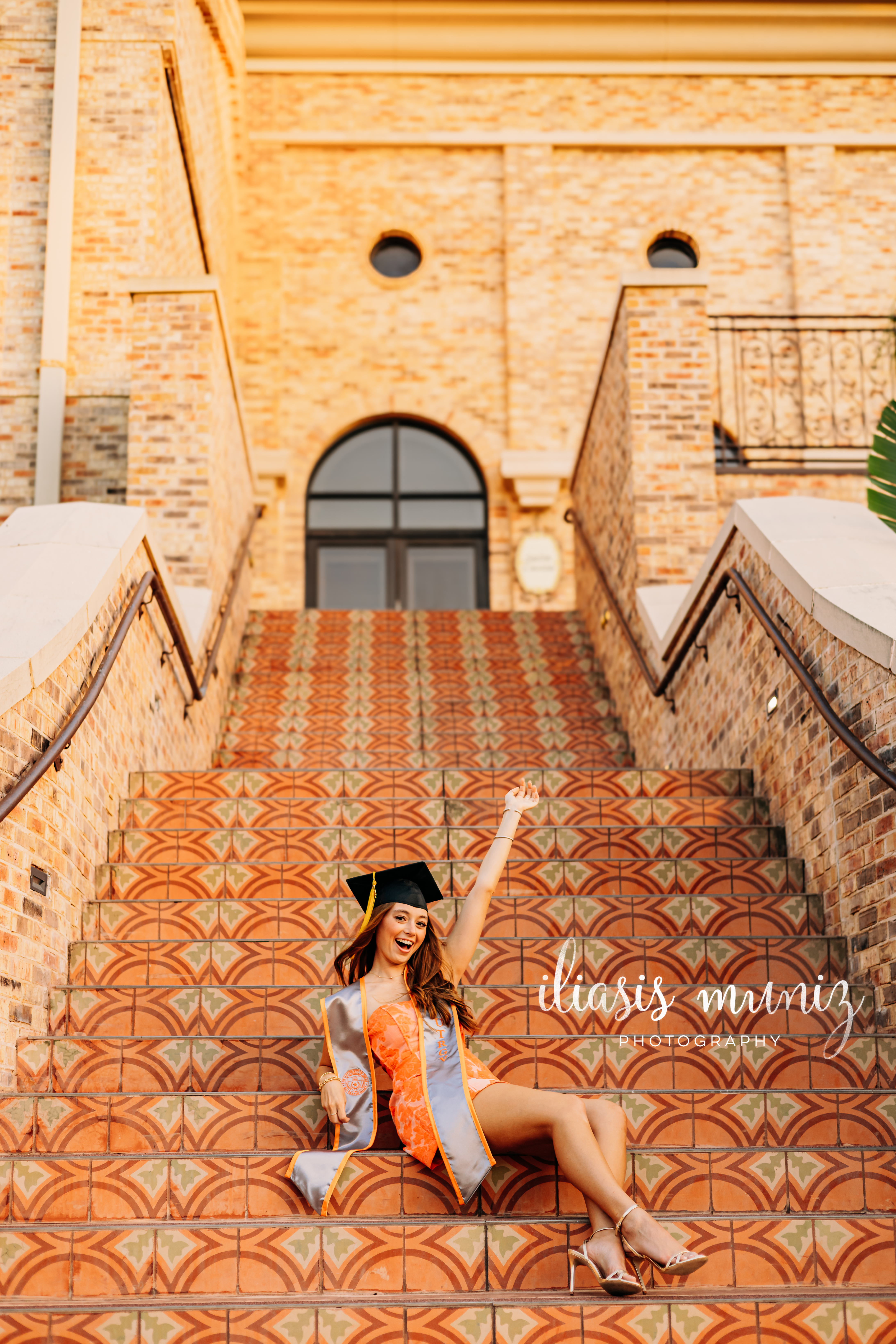 "Graduate sitting on colorful tiled staircase at UTRGV"
