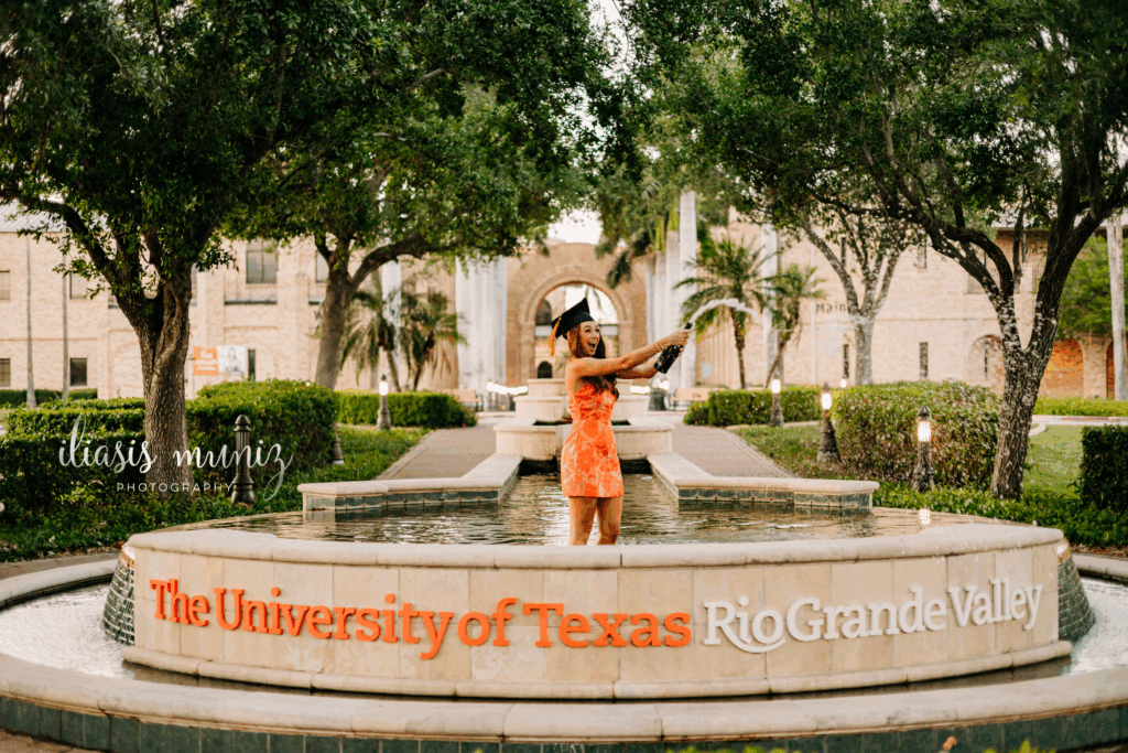 "Graduation cap and gown photo at UTRGV main campus water fountain"