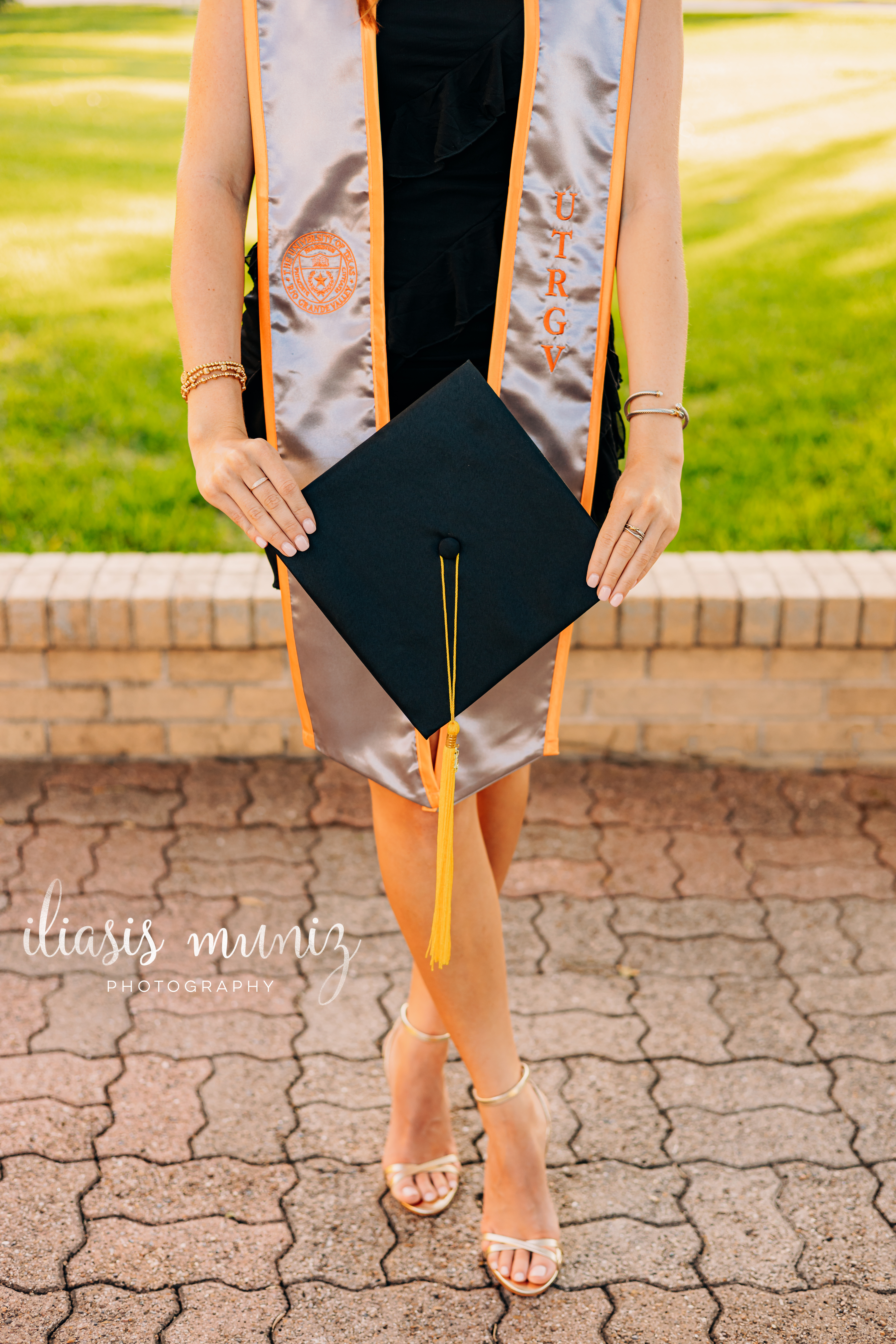 Graduate sitting on colorful tiled staircase at UTRGV
